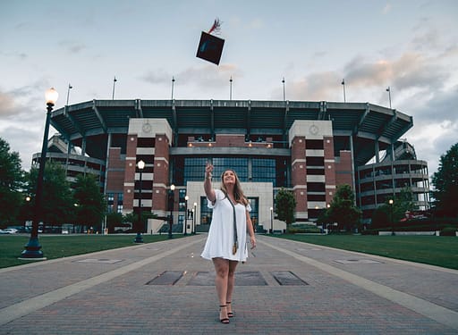 female college graduate outside stadium